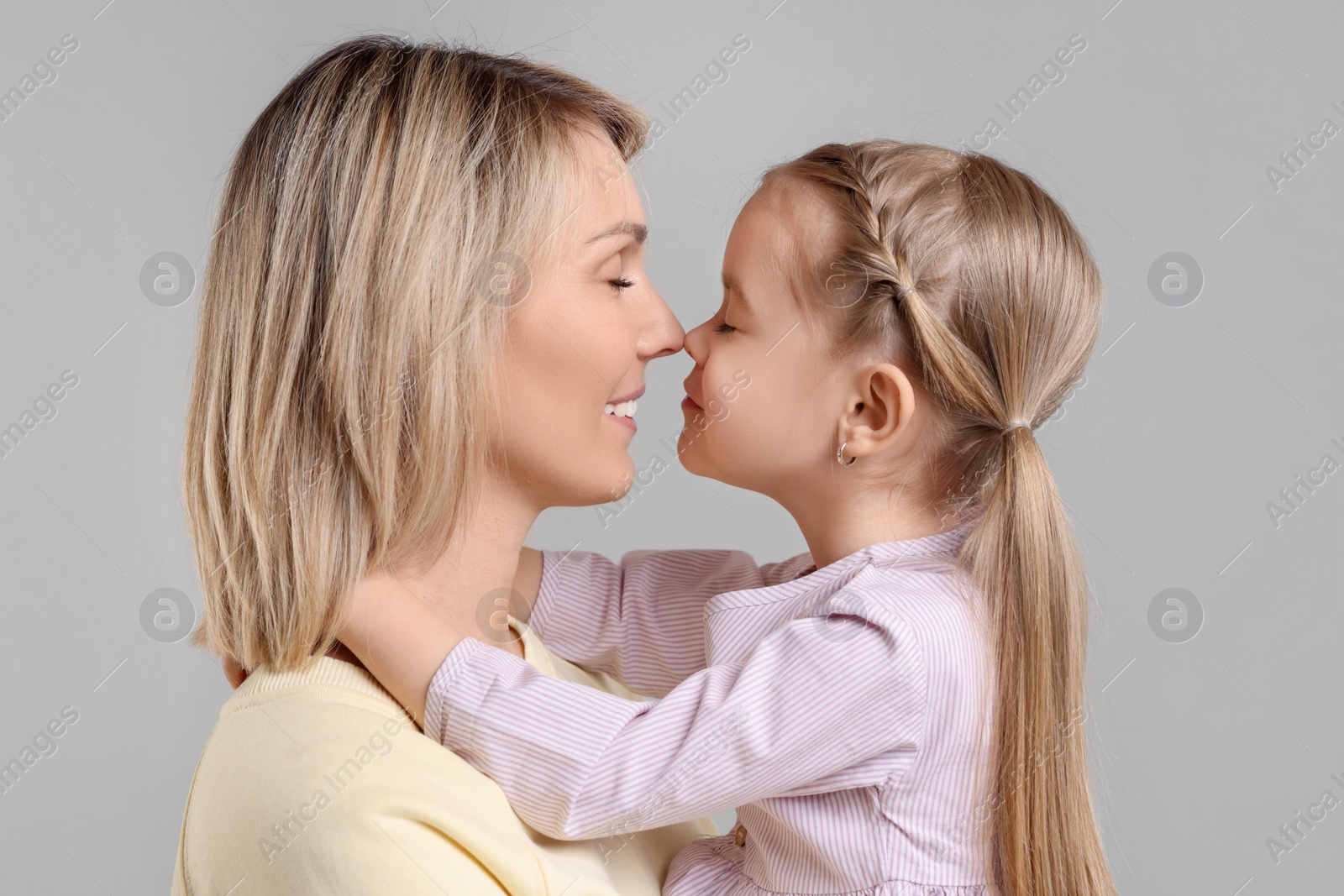 Photo of Family portrait of happy mother and daughter on grey background