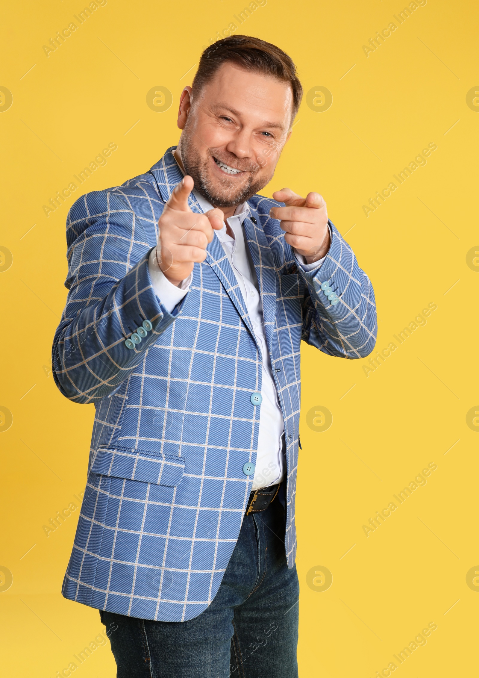 Photo of Portrait of happy mature man on yellow background