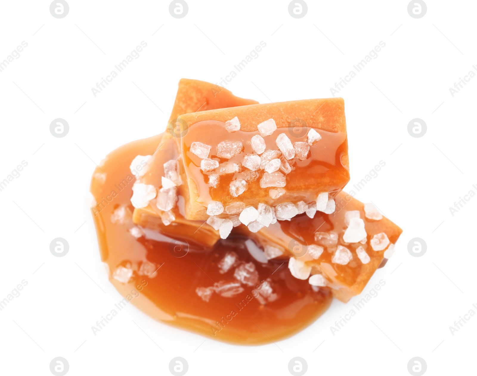 Photo of Delicious candies with caramel sauce and salt on white background