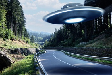 Alien spaceship flying over road in mountains. UFO