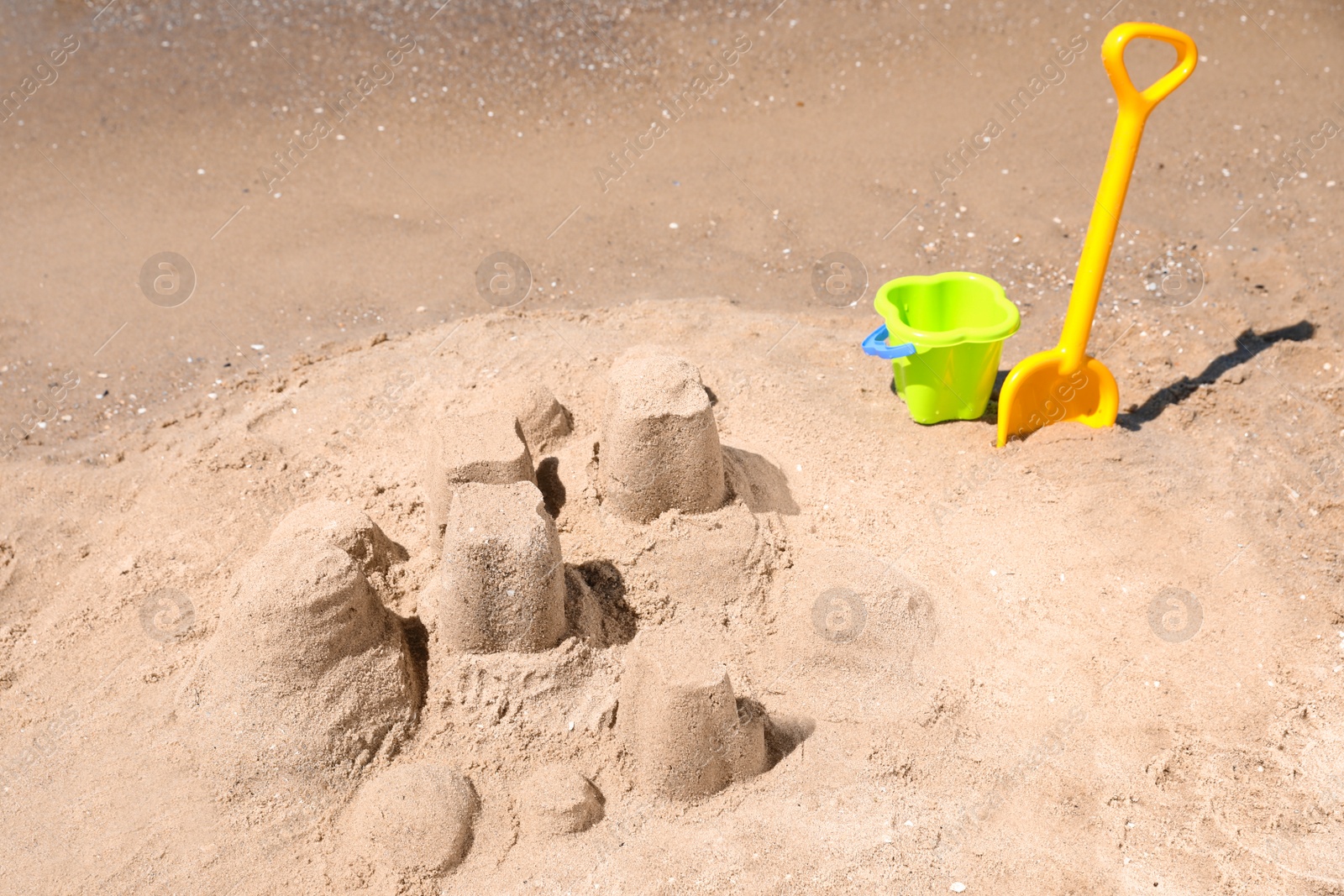 Photo of Little sand figures and plastic toys on beach near sea