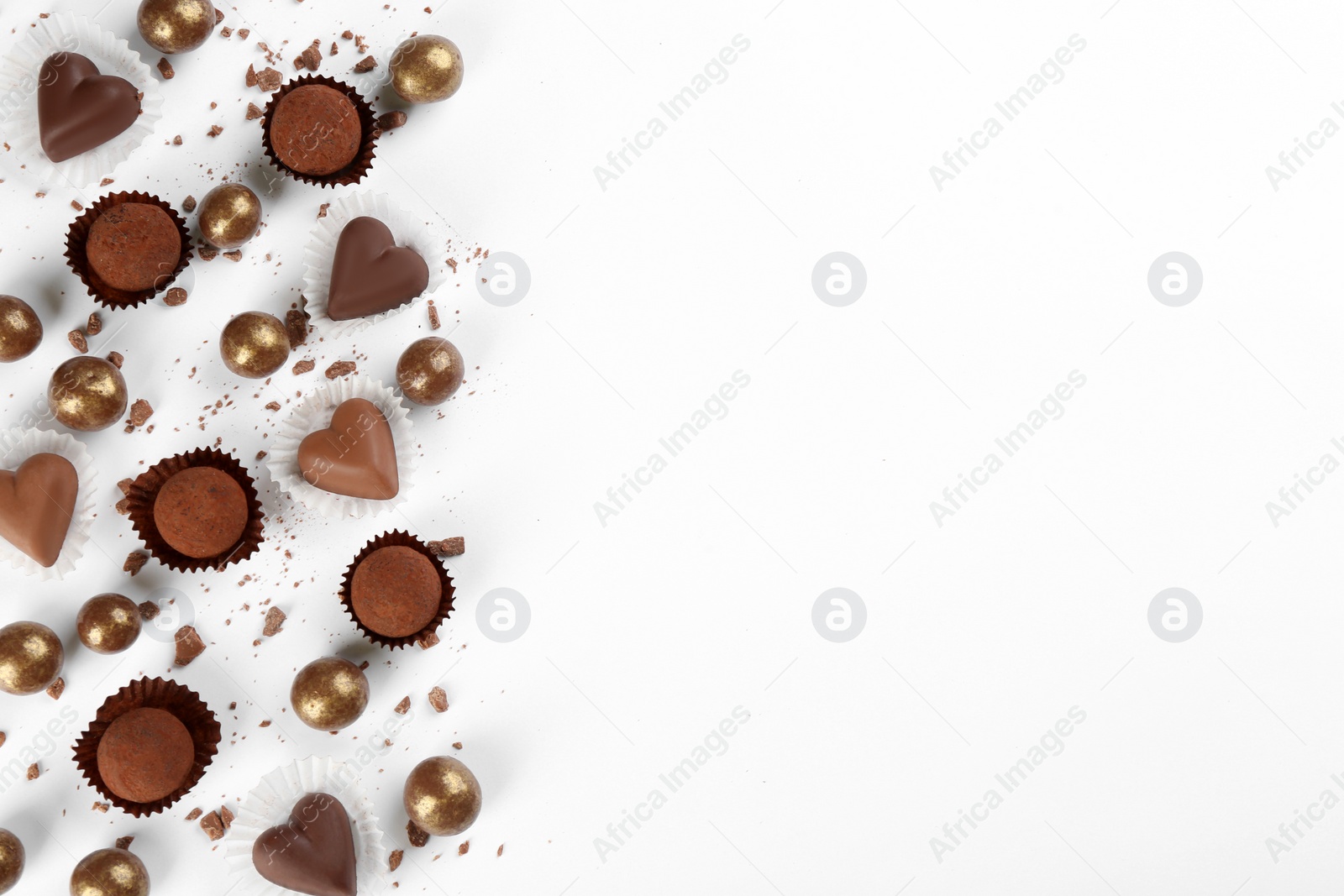 Photo of Different delicious chocolate candies on white background, flat lay. Space for text