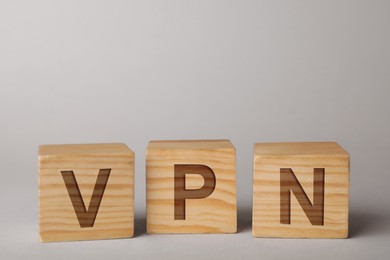 Wooden cubes with acronym VPN on light grey background