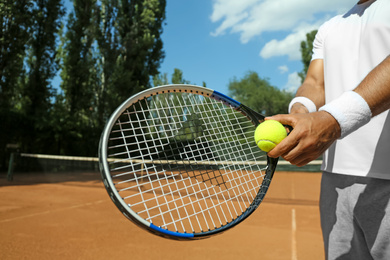 Photo of Sportsman preparing to serve tennis ball at court, closeup