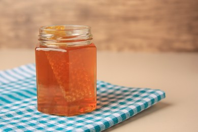 Photo of Jar with honey and combs on light table, space for text