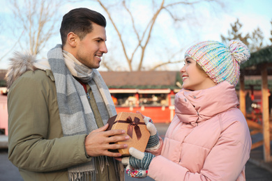 Happy couple with Christmas gift at winter fair