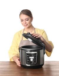 Photo of Portrait of young woman with modern multi cooker at table against white background