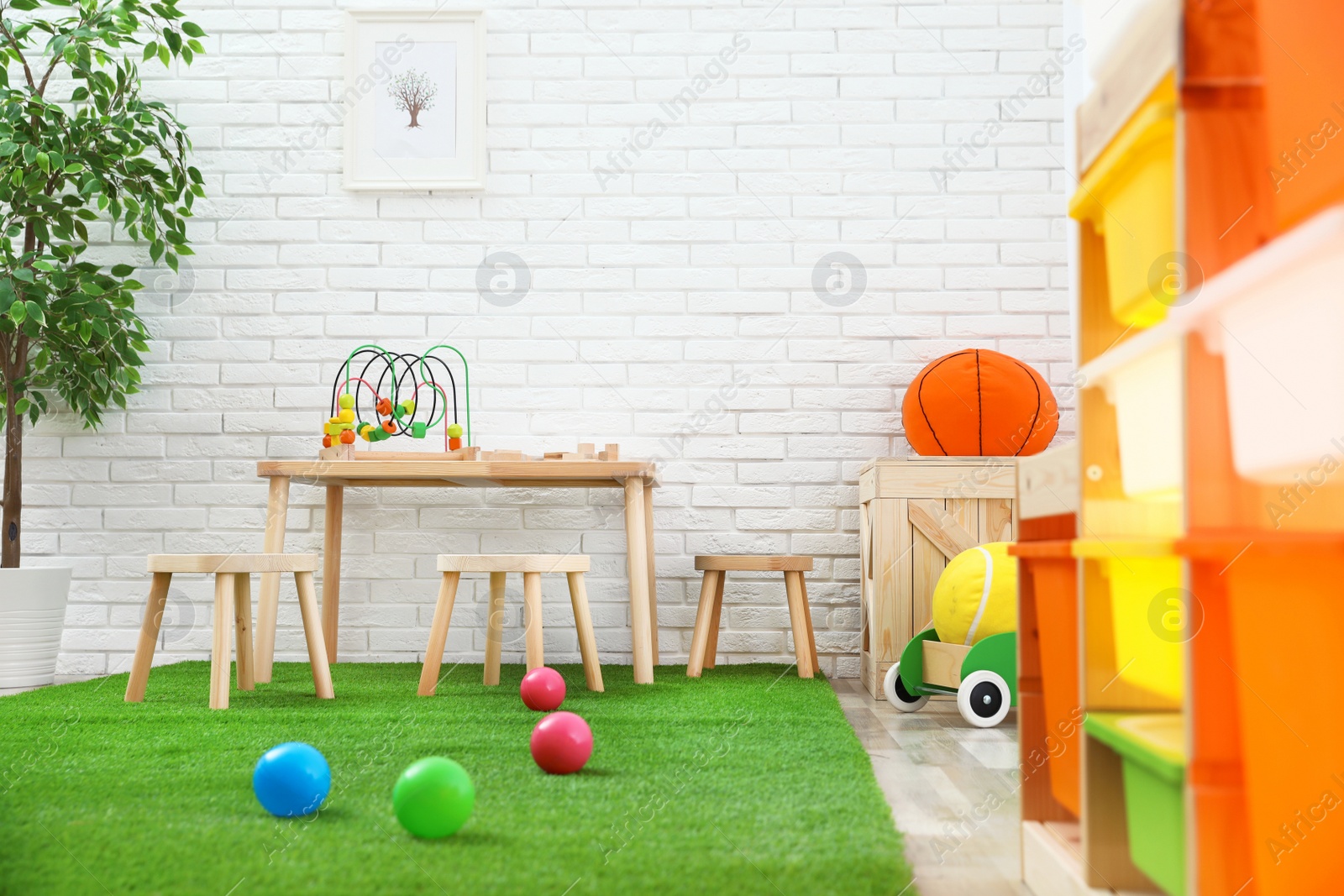 Photo of Stylish playroom interior with toys and modern wooden furniture