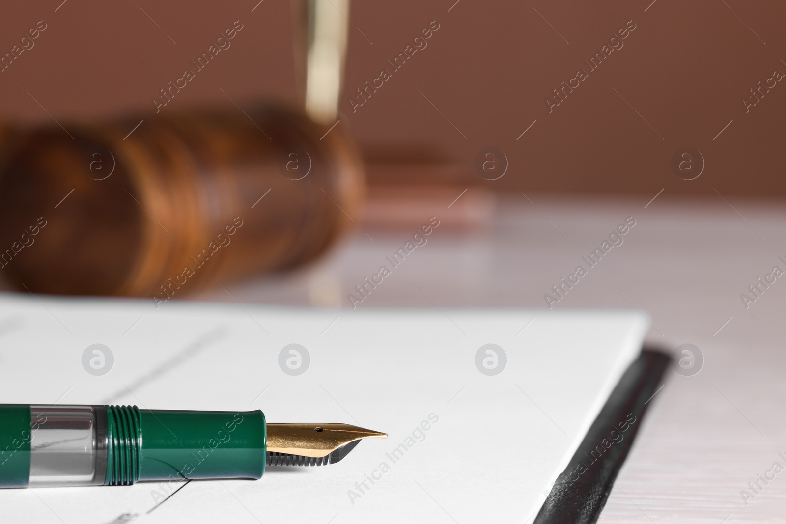 Photo of Fountain pen and paper document on table, closeup with space for text. Notary service