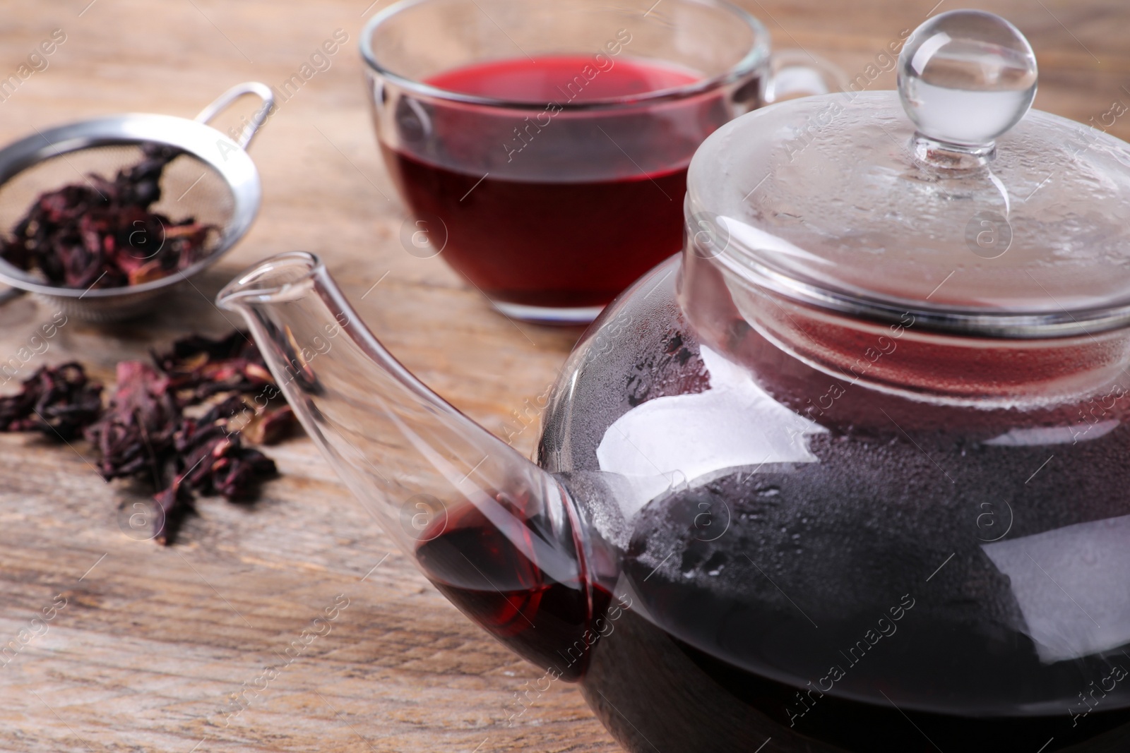 Photo of Freshly brewed hibiscus tea on wooden table, closeup