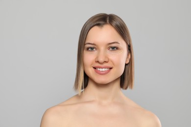 Photo of Young woman with cream around eye on light grey background