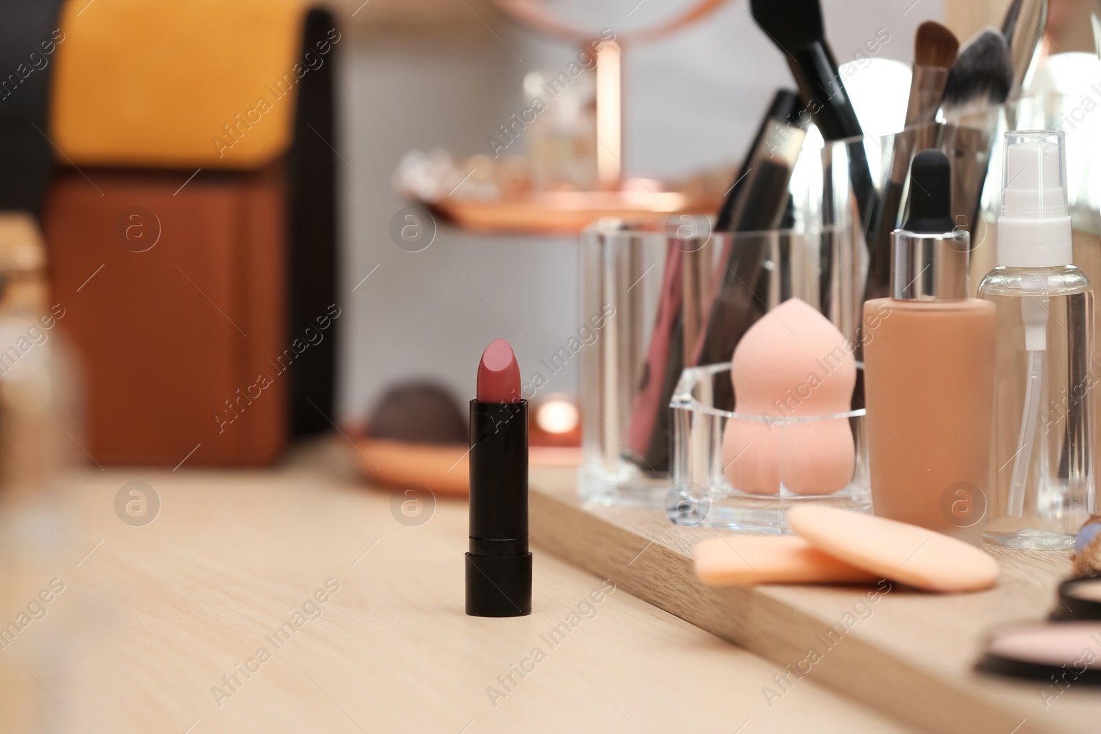 Photo of Cosmetic products and makeup accessories on dressing table. Space for text