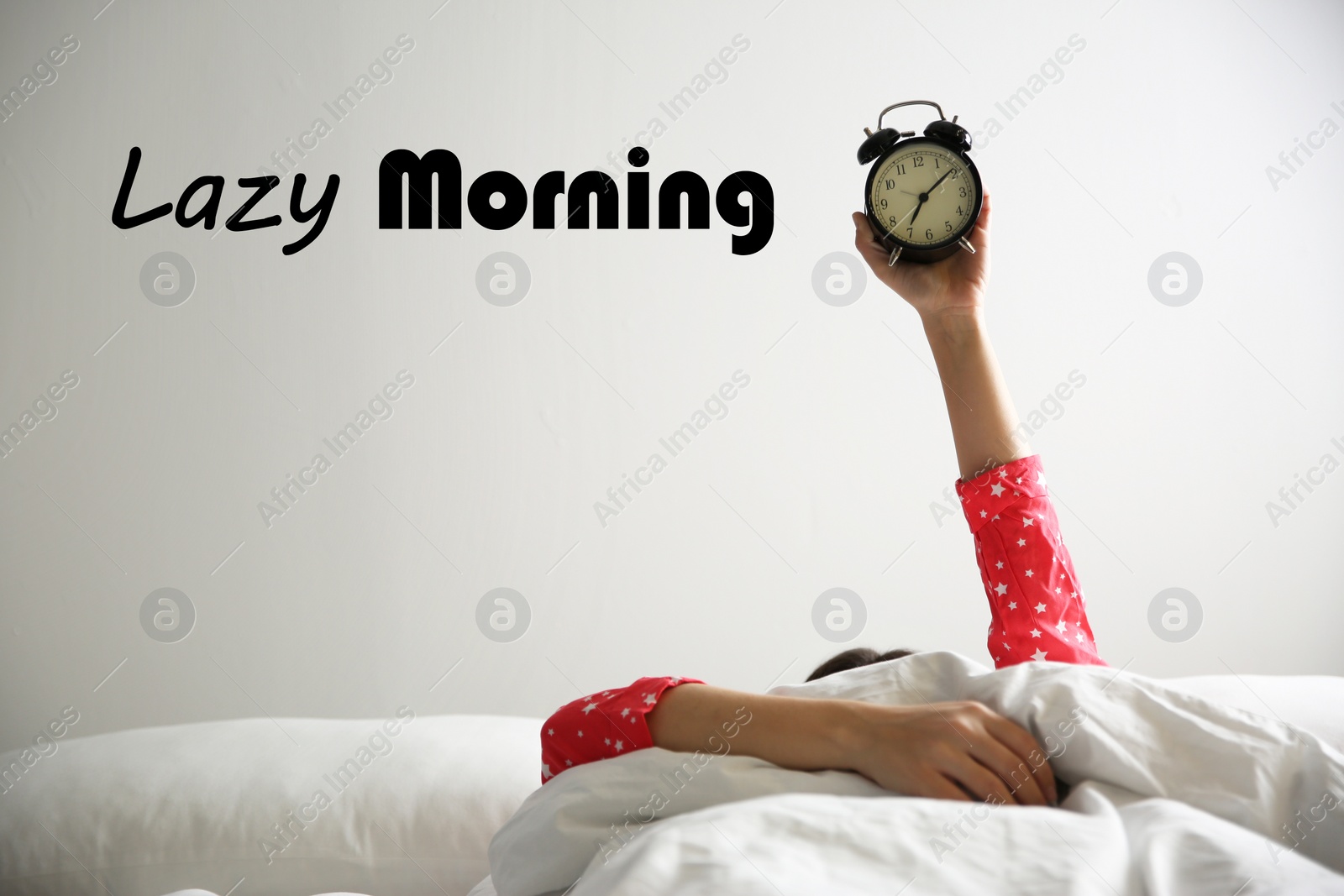 Image of Closeup view of woman with alarm clock lying in bed. Lazy morning