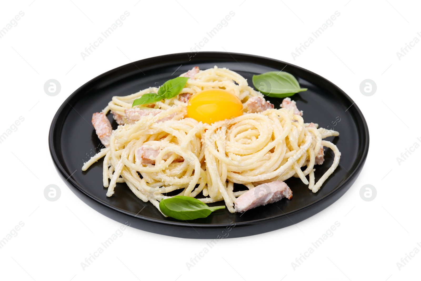 Photo of Plate of tasty pasta Carbonara with basil leaves and egg yolk isolated on white