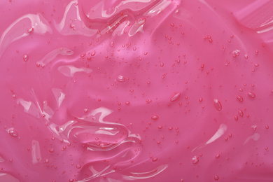 Photo of Pure transparent cosmetic gel on pink background, closeup