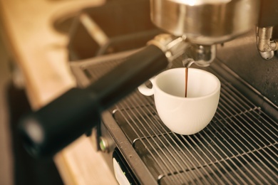 Photo of Preparing fresh aromatic coffee using modern machine, closeup