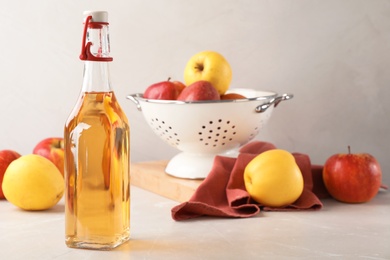 Photo of Composition with bottle of apple vinegar on table. Space for text