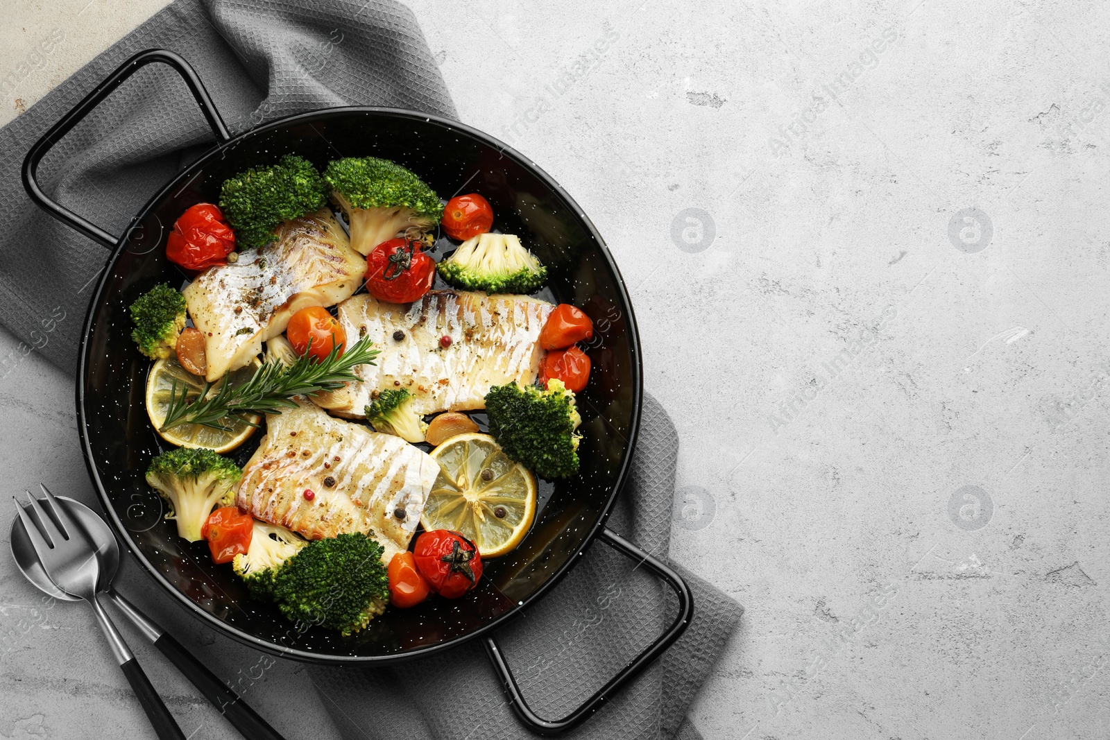 Photo of Tasty cod cooked with vegetables served on grey table, flat lay. Space for text