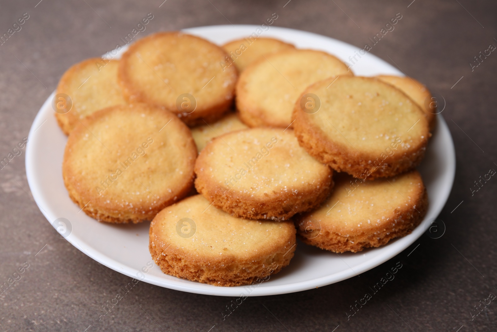 Photo of Tasty sweet sugar cookies on brown table, closeup