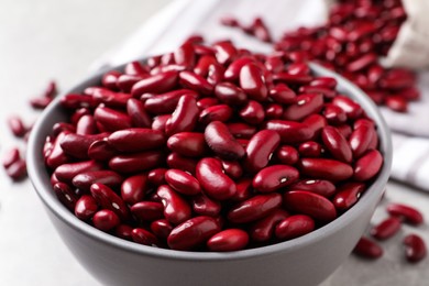 Photo of Raw red kidney beans in bowl on table, closeup