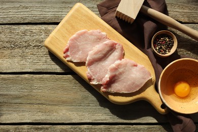 Photo of Different ingredients for cooking schnitzel on wooden table, flat lay. Space for text