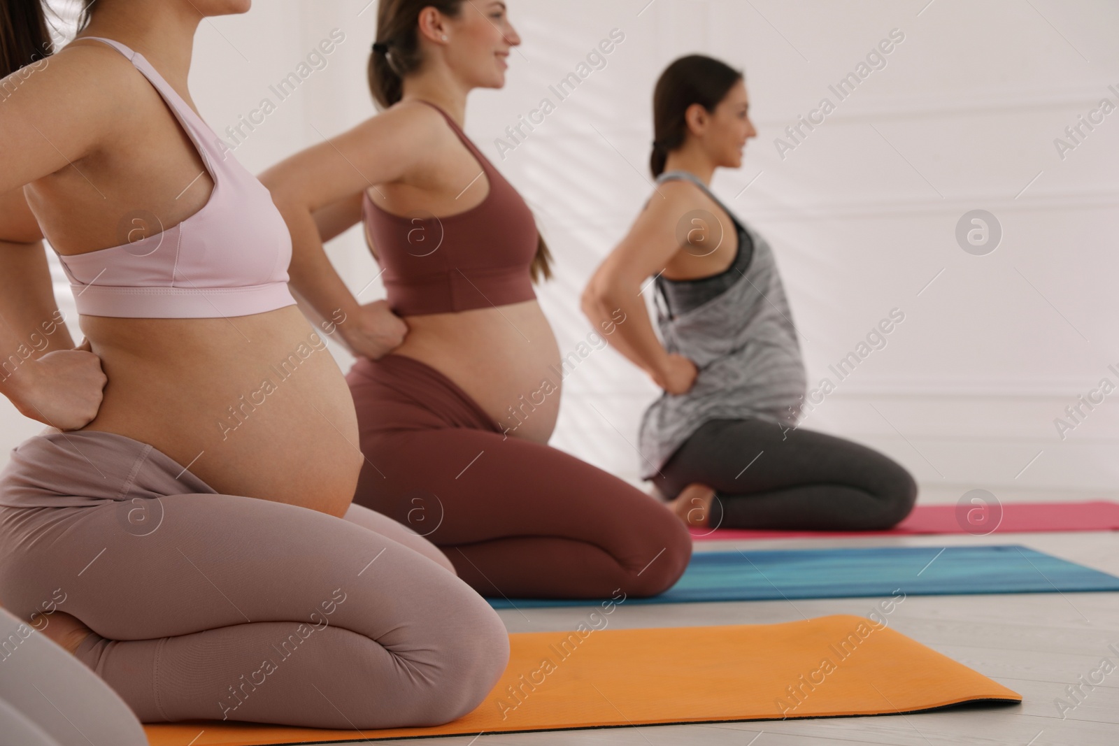 Photo of Group of pregnant women doing exercises in gym. Preparation for child birth