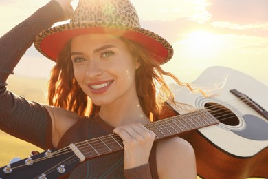 Beautiful happy hippie woman with guitar outdoors