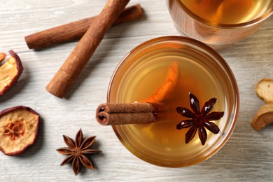 Delicious compote with dried apple slices, anise and cinnamon on white wooden table, flat lay