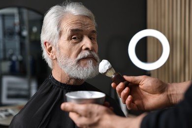 Professional barber working with client's mustache in barbershop