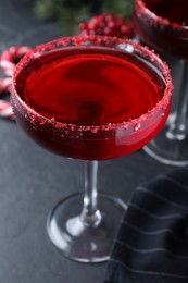Photo of Delicious Christmas cocktail with liqueur on black table, closeup