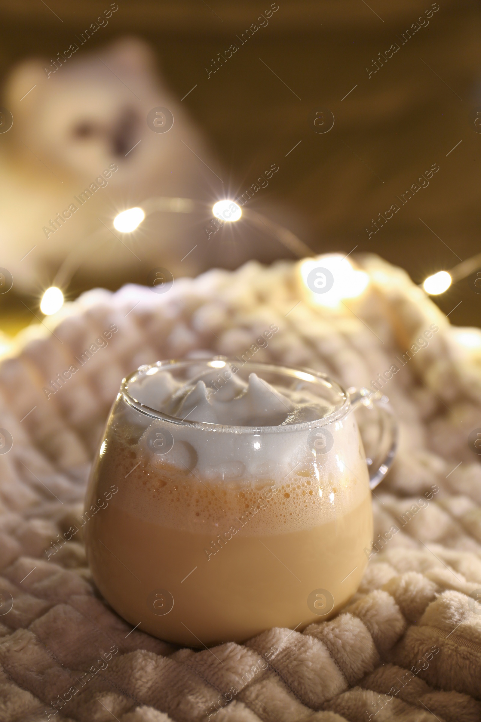 Photo of Glass cup of delicious hot cocoa on light blanket