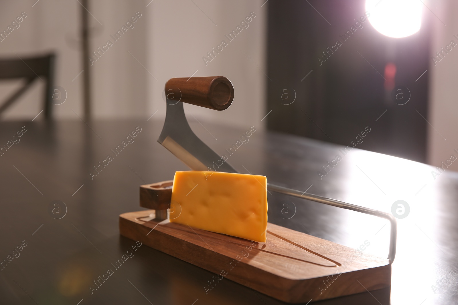 Photo of Slicer and piece of cheese on table
