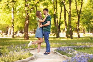 Happy young couple in green park on sunny spring day