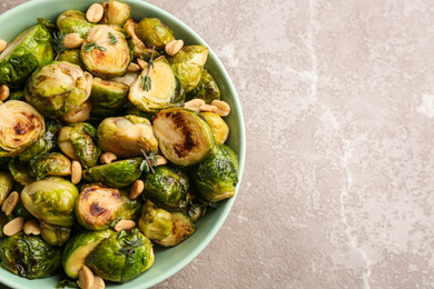 Photo of Delicious roasted brussels sprouts with peanuts on grey marble table, top view. Space for text
