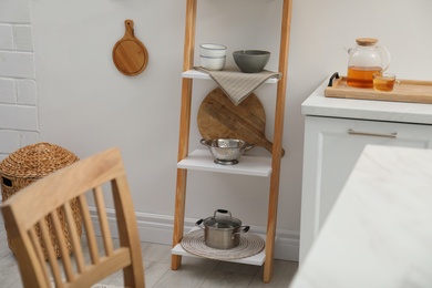 Stylish kitchen room interior with wooden ladder near white wall