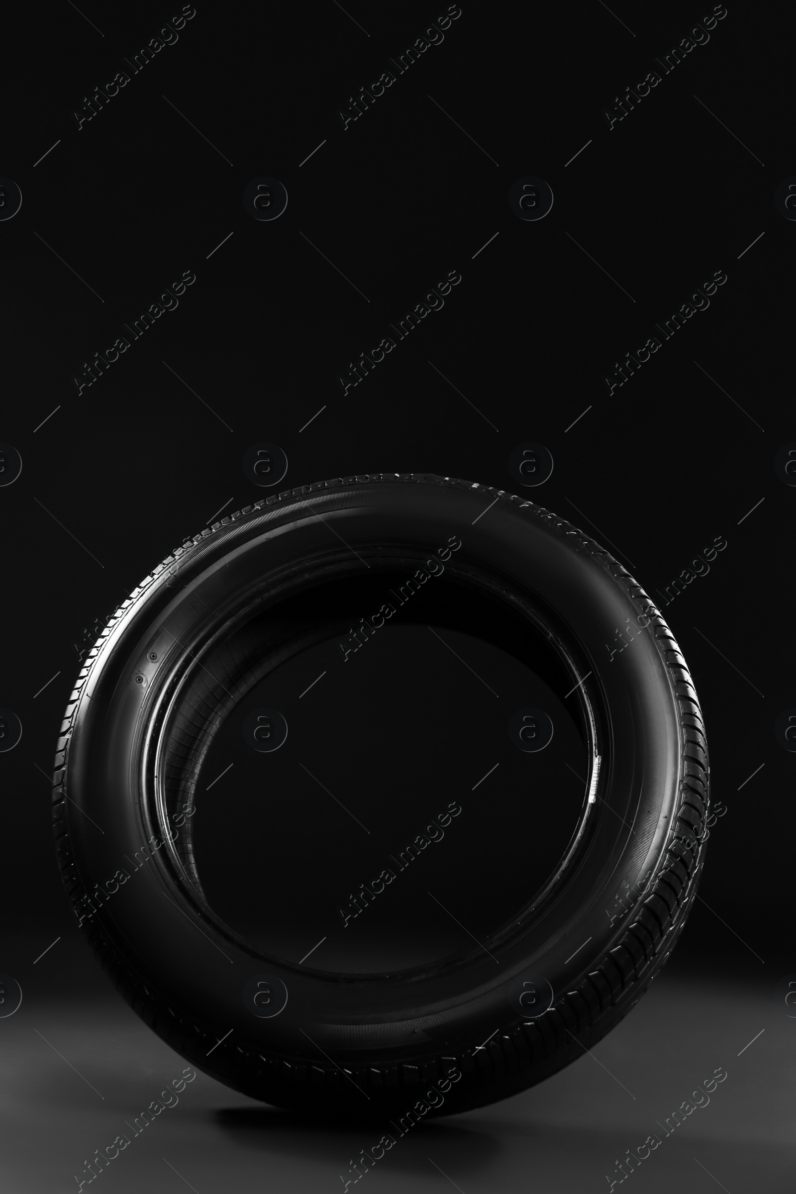 Photo of New car tire on black background