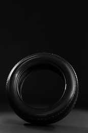 Photo of New car tire on black background