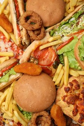 Photo of French fries, pizza and other fast food as background, top view