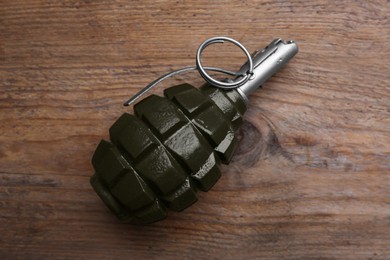 Photo of Hand grenade on wooden table, top view