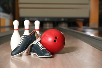 Shoes, pins and ball on bowling lane in club