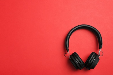 Photo of Stylish headphones on color background, top view. Space for text