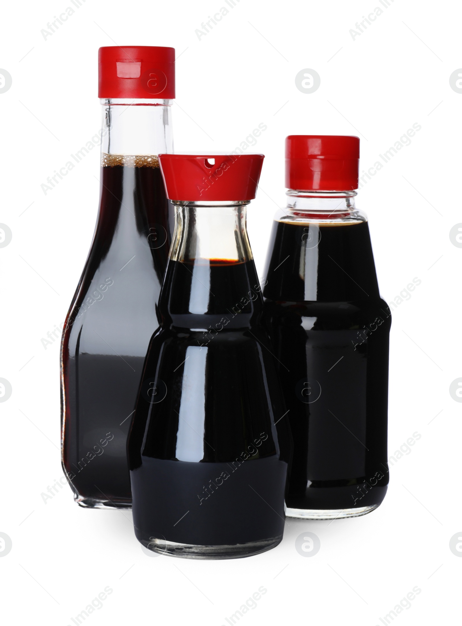 Photo of Bottles of tasty soy sauce isolated on white