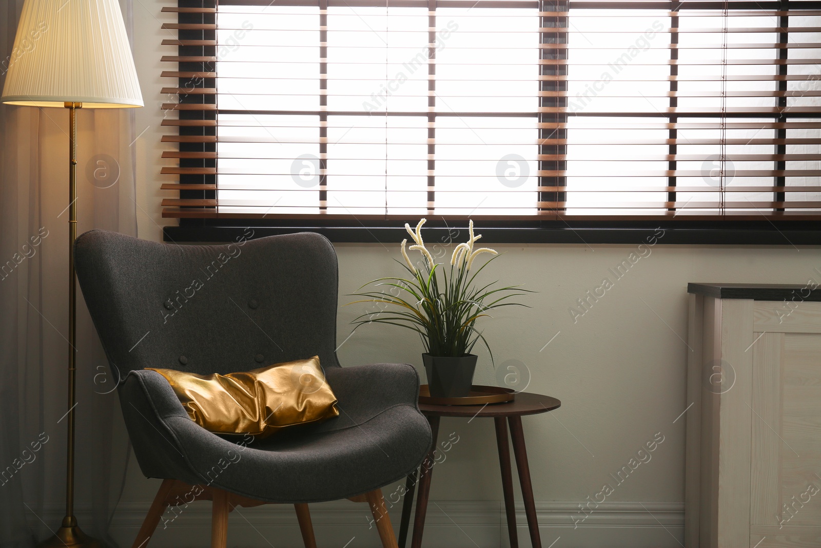 Photo of Stylish living room interior with comfortable armchair and window blinds