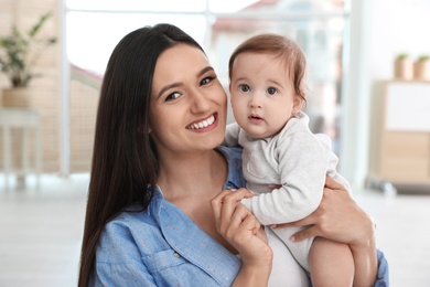 Portrait of young mother and her adorable baby at home