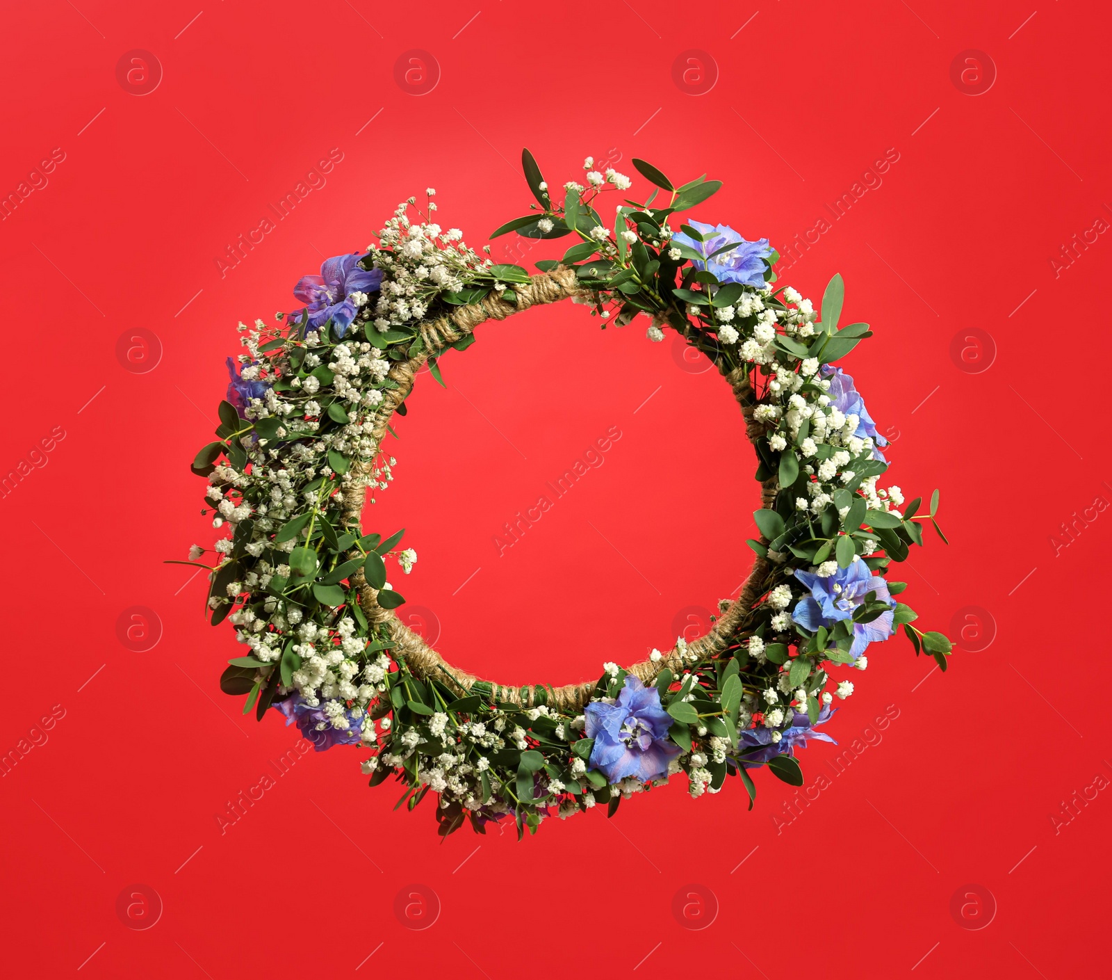 Photo of Beautiful handmade flower wreath on red background