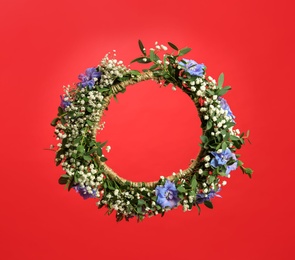 Beautiful handmade flower wreath on red background