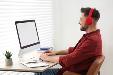 Photo of Man in headphones studying on computer at home. Online translation course