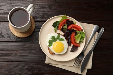 Delicious breakfast with fried egg and salad served on wooden table, flat lay