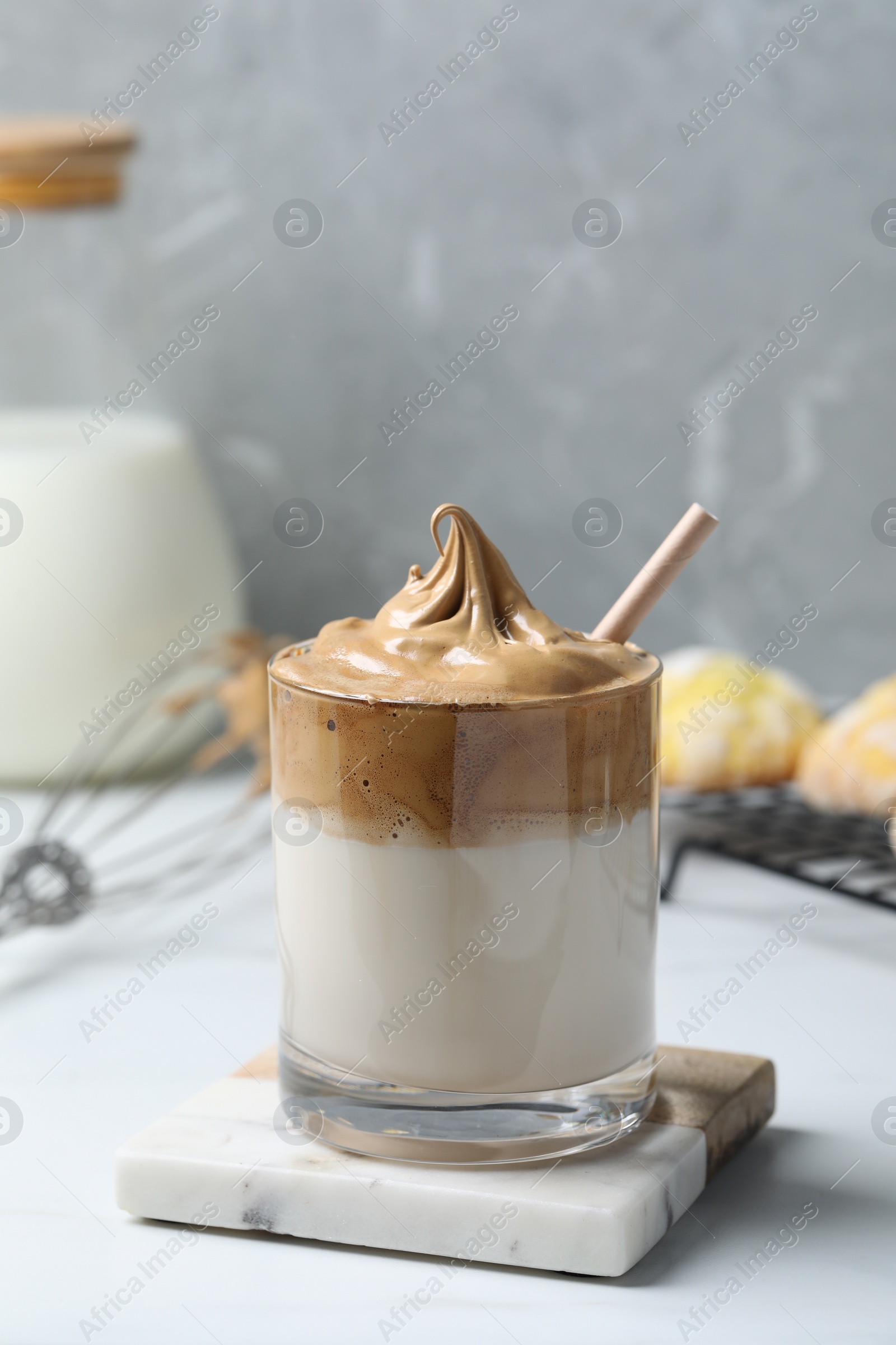 Photo of Glass of delicious dalgona coffee on white table