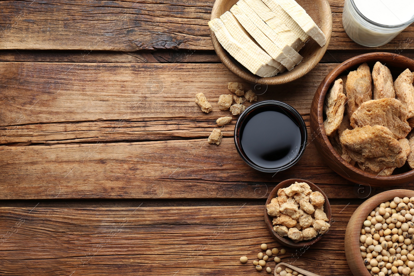 Photo of Different natural soy products on wooden table, flat lay. Space for text